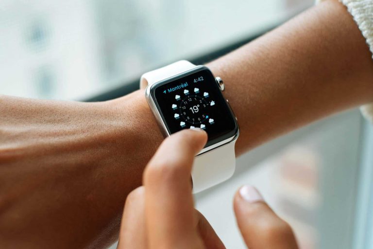 A woman's hand, as seen in a Seller Central management setting, is pointing at an Apple Watch.